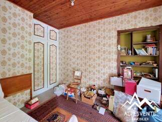 Discover this charming room featuring a classic wooden ceiling and patterned wallpaper, creating a warm and inviting atmosphere.