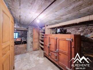 Discover the unique charm of this property's basement, featuring rustic stone walls and exposed concrete ceilings.