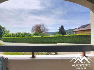 Enjoy breathtaking mountain views from this charming property, featuring a well-maintained hedge and a clear blue sky.