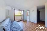 This bright living room features a comfortable sofa and direct access to a balcony with scenic views.