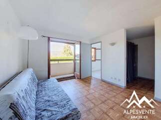 This bright living room features a comfortable sofa and direct access to a balcony with scenic views.