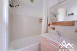 This bathroom features a clean and modern design with a spacious bathtub and a sleek vanity.