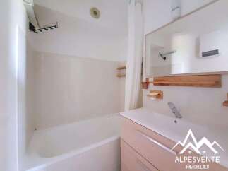 This bathroom features a clean and modern design with a spacious bathtub and a sleek vanity.