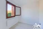 This bright and airy room features a large wooden-framed window offering scenic views of lush greenery and distant hills.