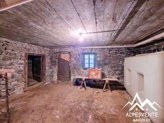Discover the rustic charm of this basement space, featuring exposed stone walls and a wooden ceiling.