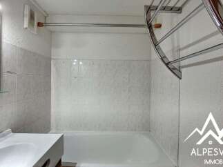 This bathroom features a clean white bathtub and a modern sink with a chrome faucet.