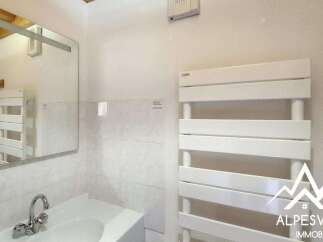 This bright bathroom features a modern white towel warmer, perfect for keeping your towels cozy.