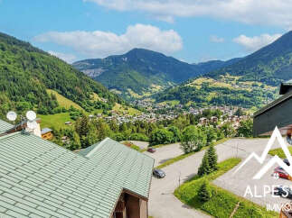 Experience breathtaking mountain vistas from this stunning property, offering panoramic views of a charming alpine village nestled in a lush valley.
