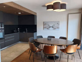 Experience modern living in this stylish apartment featuring a sleek, dark-toned kitchen with integrated appliances and ample counter space.