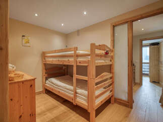 This charming bedroom features a sturdy wooden bunk bed, perfect for accommodating guests or children.