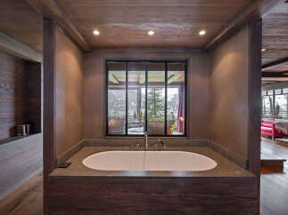 Experience ultimate relaxation in this luxurious bathroom featuring a deep soaking tub with stunning mountain views.