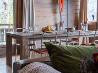 Experience rustic charm in this dining area, featuring a substantial wooden table perfect for gatherings, complemented by sleek metal-framed chairs.