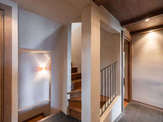 Discover this charming staircase, featuring warm wooden steps and a sleek black metal railing, perfect for ascending to the upper levels of your home.