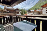 Enjoy breathtaking mountain views from this charming balcony, complete with a table and chairs for al fresco dining.
