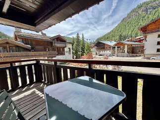 Enjoy breathtaking mountain views from this charming balcony, complete with a table and chairs for al fresco dining.