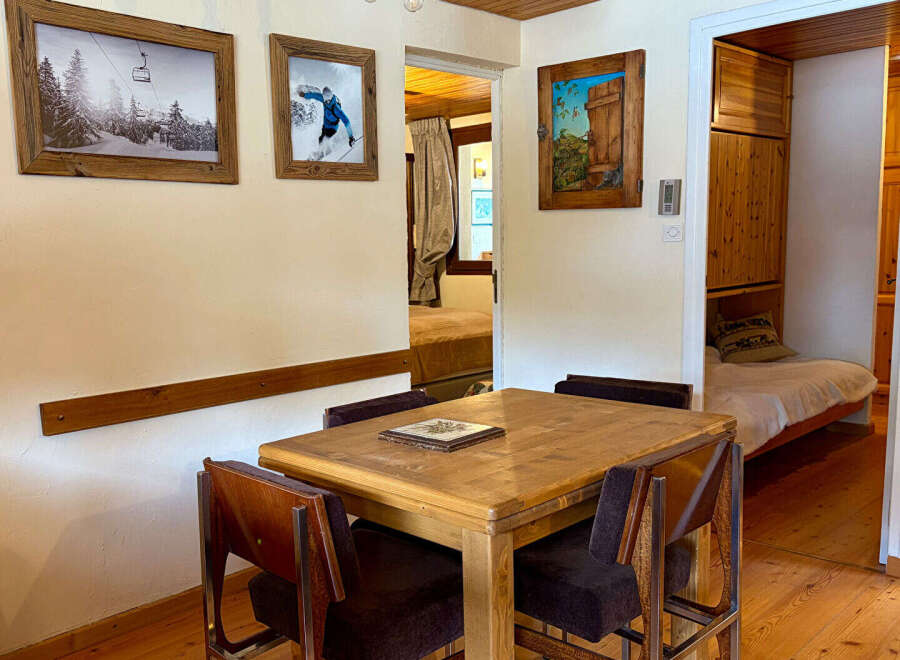 This charming property features a cozy dining area with a wooden table and chairs, perfect for intimate meals.
