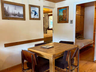 This charming property features a cozy dining area with a wooden table and chairs, perfect for intimate meals.