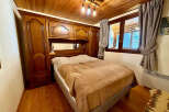 Experience cozy mountain living in this charming bedroom featuring a warm wooden ceiling and floor.