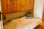 This cozy bedroom features a comfortable single bed with a plush white blanket, perfect for a relaxing retreat.