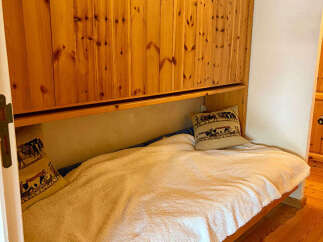 This cozy bedroom features a comfortable single bed with a plush white blanket, perfect for a relaxing retreat.