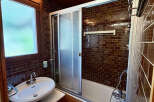 This charming bathroom features a sleek bathtub with a sliding glass door, perfect for a relaxing soak.