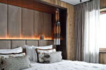 Experience rustic luxury in this master bedroom, featuring a plush upholstered headboard with integrated ambient lighting.