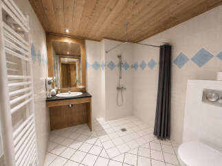 This spacious bathroom features a large walk-in shower with a dark grey curtain, perfect for a relaxing experience.