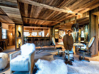 Experience rustic luxury in this stunning chalet-style living space, featuring warm wooden interiors and a cozy bar area perfect for entertaining.