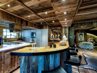 Experience luxury mountain living in this stunning chalet featuring a rustic yet modern open-plan kitchen and bar area.