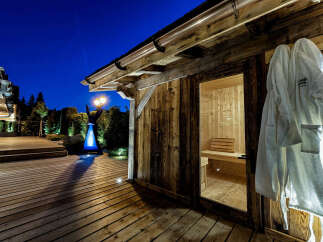 Experience ultimate relaxation in this luxurious wooden sauna, complete with plush white robes hanging ready for use.