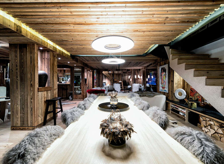 Experience luxury mountain living in this stunning chalet, featuring a grand live-edge dining table perfect for entertaining.