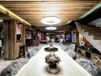 Experience luxury mountain living in this stunning chalet, featuring a grand live-edge dining table perfect for entertaining.