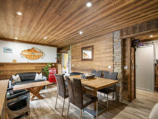 Experience rustic charm in this inviting dining area, featuring a warm wooden ceiling and walls complemented by a striking stone accent wall.