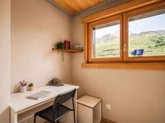 Discover this charming room featuring a functional desk area, perfect for work or study, complemented by a cozy chair.