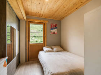Experience cozy living in this charming bedroom featuring a comfortable single bed with soft linens and pillows.