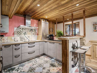 Experience rustic charm in this unique kitchen featuring a vibrant, patterned tile backsplash and a coordinating floor.