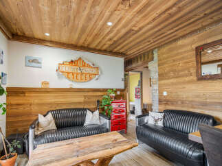 Experience rustic charm in this inviting living space, featuring warm wood paneling on the walls and ceiling.