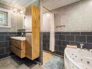 Experience modern comfort in this stylish bathroom, featuring a sleek vanity with ample storage and a luxurious jacuzzi tub perfect for unwinding.