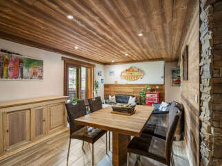 Experience rustic charm in this inviting dining area, featuring a warm wooden ceiling and stone accent wall.
