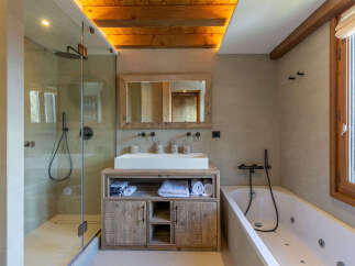 Experience luxury in this modern bathroom featuring a spacious walk-in shower and a deep soaking tub, perfect for relaxation.