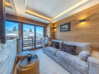Experience cozy mountain living in this charming living room featuring a plush sofa and warm wood-paneled walls.