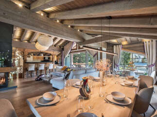 Experience luxury mountain living in this stunning chalet, featuring a spacious open-plan living area with a modern fireplace and a fully equipped bar.
