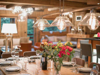Experience elegant dining in this beautifully appointed space, featuring a large wooden table set for a feast.