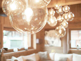 Experience luxurious living with this stunning interior featuring a modern sectional sofa and elegant glass globe pendant lights.