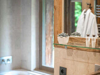Experience rustic luxury in this charming bathroom, featuring a deep soaking tub and a unique stone sink.