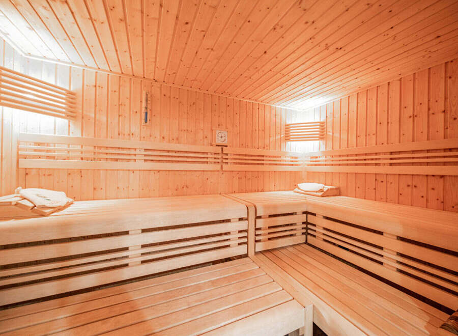 Experience ultimate relaxation in this luxurious wooden sauna, featuring multiple tiers of comfortable seating perfect for unwinding.