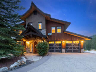 Experience luxury mountain living in this stunning custom-built home, nestled under a starry night sky.