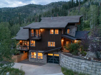 Nestled amidst a lush mountain landscape, this stunning home offers a perfect blend of rustic charm and modern luxury.