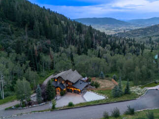 Nestled amidst a lush forest, this stunning mountain home offers a serene escape with breathtaking valley views.