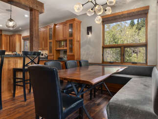 Experience rustic charm and modern comfort in this inviting dining area, featuring a stunning live-edge wood table perfect for gatherings.